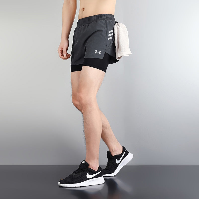 e743c9d7 | UAE SPORT STORE Side view of a person wearing dark athletic shorts with a towel tucked at the hip, and black Nike sneakers.