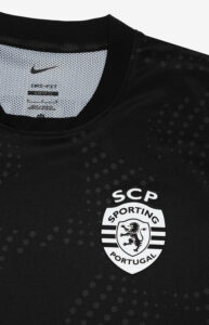 Close-up of a black sports jersey showing the SCP Sporting Portugal crest on the chest and a white Nike swoosh near the collar.