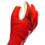 Close-up of a red athletic glove with black grip stripes and a white Nike swoosh logo