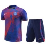 Paris Saint-Germain football jersey and matching shorts in blue with a red geometric pattern, featuring the PSG crest and a white Nike swoosh.
