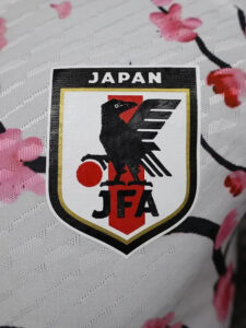 Japan Football Association crest featuring a black eagle, red circle, and 'JFA' on a shield.