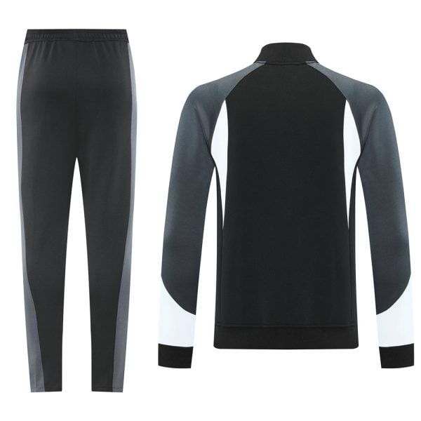 Back view of a two-tone athletic tracksuit: black jacket with gray sleeves and white cuffs, paired with black pants with gray side panels.