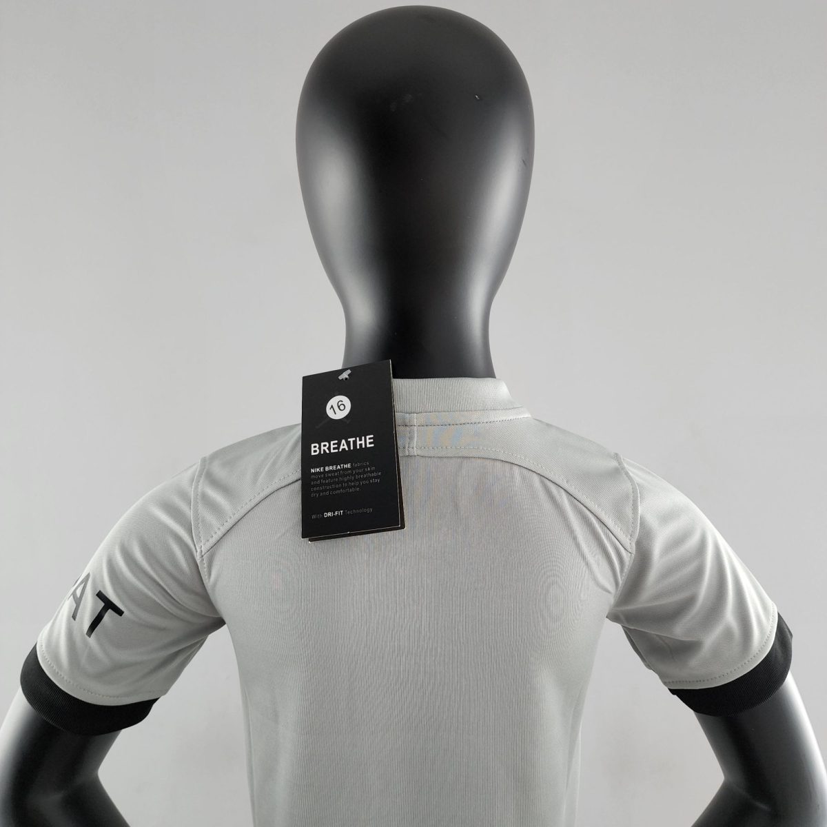 Black mannequin torso wearing a light gray athletic shirt, with a black tag hanging at the chest area that reads 'BREATHE'.