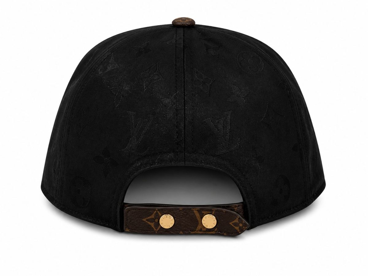 Back view of a black Louis Vuitton cap with an adjustable brown leather strap and gold studs, showing the monogram pattern
