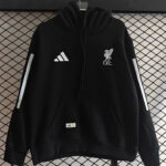 ea151e7b-5c2f-4a2a-b809-c58e4b51469c | UAE SPORT STORE Black hoodie with white Liverbird crest and 'L.F.C.' on the chest, and Adidas logo on the left chest, displayed against a grid backdrop.
