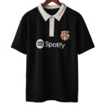 Black polo shirt with a white collar on a wooden hanger, featuring the Spotify logo and FC Barcelona crest on the chest.