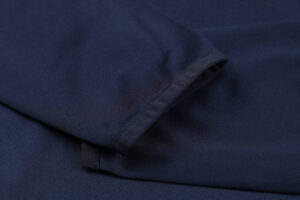 Close-up of dark navy blue fabric with a folded hem and seam detail.