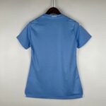 Back view of a blue polo shirt on a hanger, with 'CITY' printed on the collar.