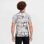 Man wearing a white graphic T-shirt with black graffiti-style text, shown from the back against a light background.