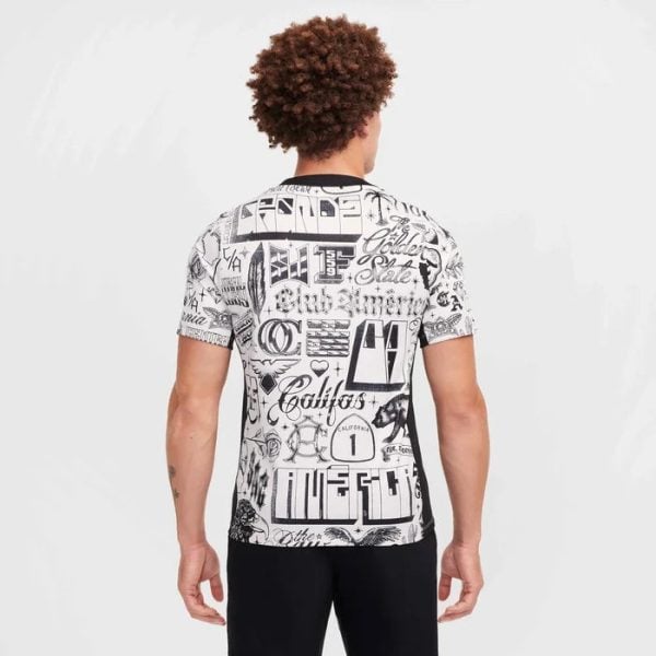 Man wearing a white graphic T-shirt with black graffiti-style text, shown from the back against a light background.