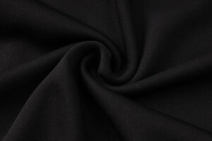 Close-up of black fabric with soft folds and a textured weave.