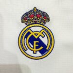 ed03da2f-d6fc-4286-83dd-2b483de8e448 | UAE SPORT STORE Embroidered Real Madrid crest on white fabric with a crown above the badge.