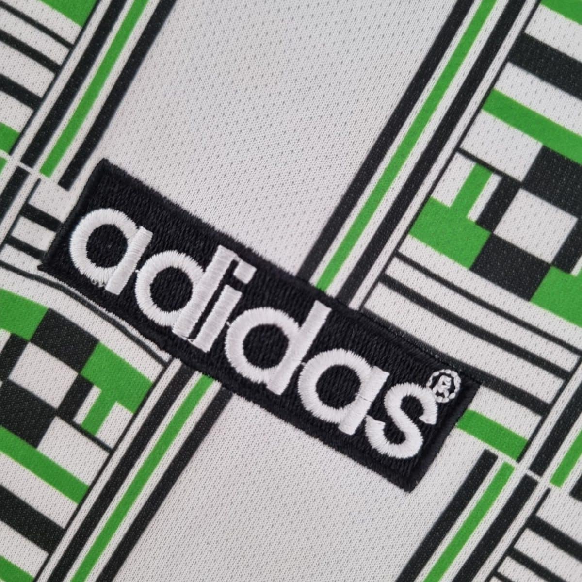 Close-up of a black, white, and green geometric fabric pattern on textured material.