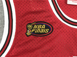 Red basketball jersey with a stitched NBA Finals patch featuring a trophy and the words 'NBA Finals' on the chest area