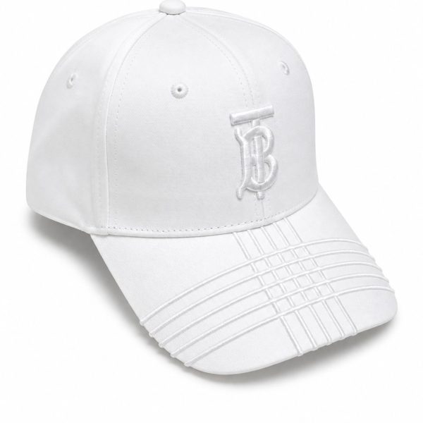 White baseball cap with a stitched monogram on the front, curved brim with decorative stitching, and small ventilation eyelets.