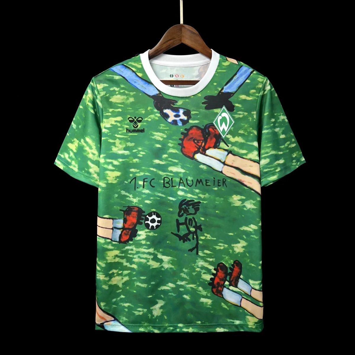 Green Werder Bremen football jersey on a hanger with a white collar, featuring the Hummel logo and playful doodles.