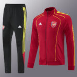 Arsenal training tracksuit: red zip-up jacket with yellow piping and matching black pants with yellow stripes