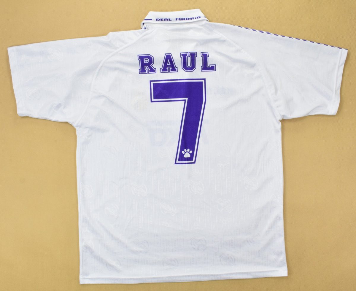 White athletic jacket laid flat, back shows the name RAUL in purple letters and a large purple number 7 on a tan background.