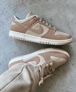 Beige Nike sneakers on a gray concrete floor, shown from the side and a close-up of the toe box, laces tied loosely.