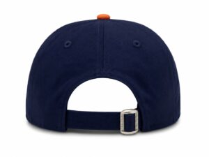 Back view of a navy blue baseball cap with an orange top button and adjustable strap with a metal buckle