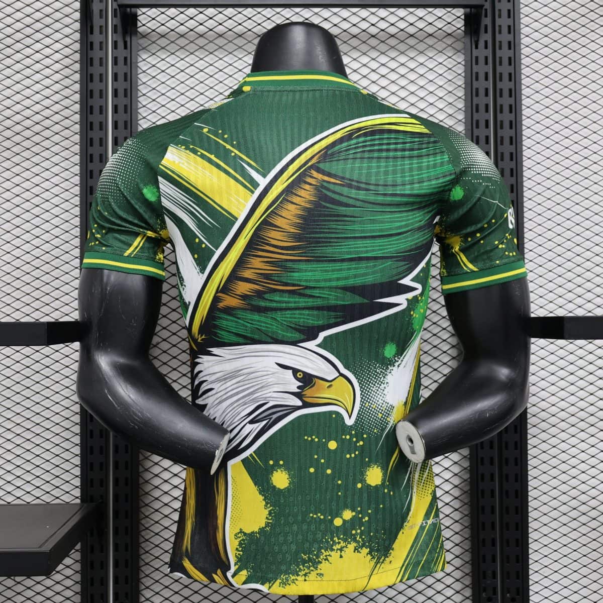 Mannequin torso wearing a green, yellow, and white abstract sports jersey, seen from the back.