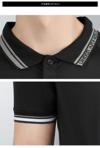 Close-up of a black polo shirt showing a striped collar and cuff, with a button at the placket.