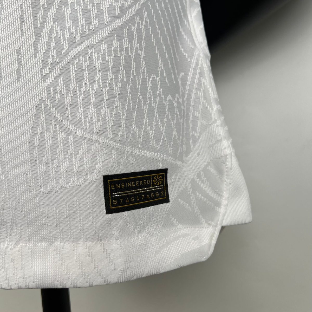 Close-up of white patterned fabric with a small black label that reads ENGINEERED.