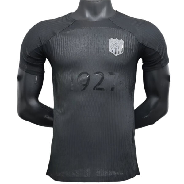 Black training jersey on a mannequin with a silver shield crest on the left chest and the number 92 faded across the front.