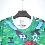 Colorful Werder Bremen jersey on a hanger, showing team crest and Hummel logo with label inside the neck area.