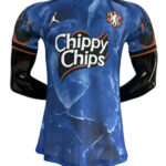 Blue athletic jersey featuring the 'Chippy Chips' sponsor logo and team crest on the chest, with a Puma logo and black sleeves with orange trim, displayed on a mannequin.