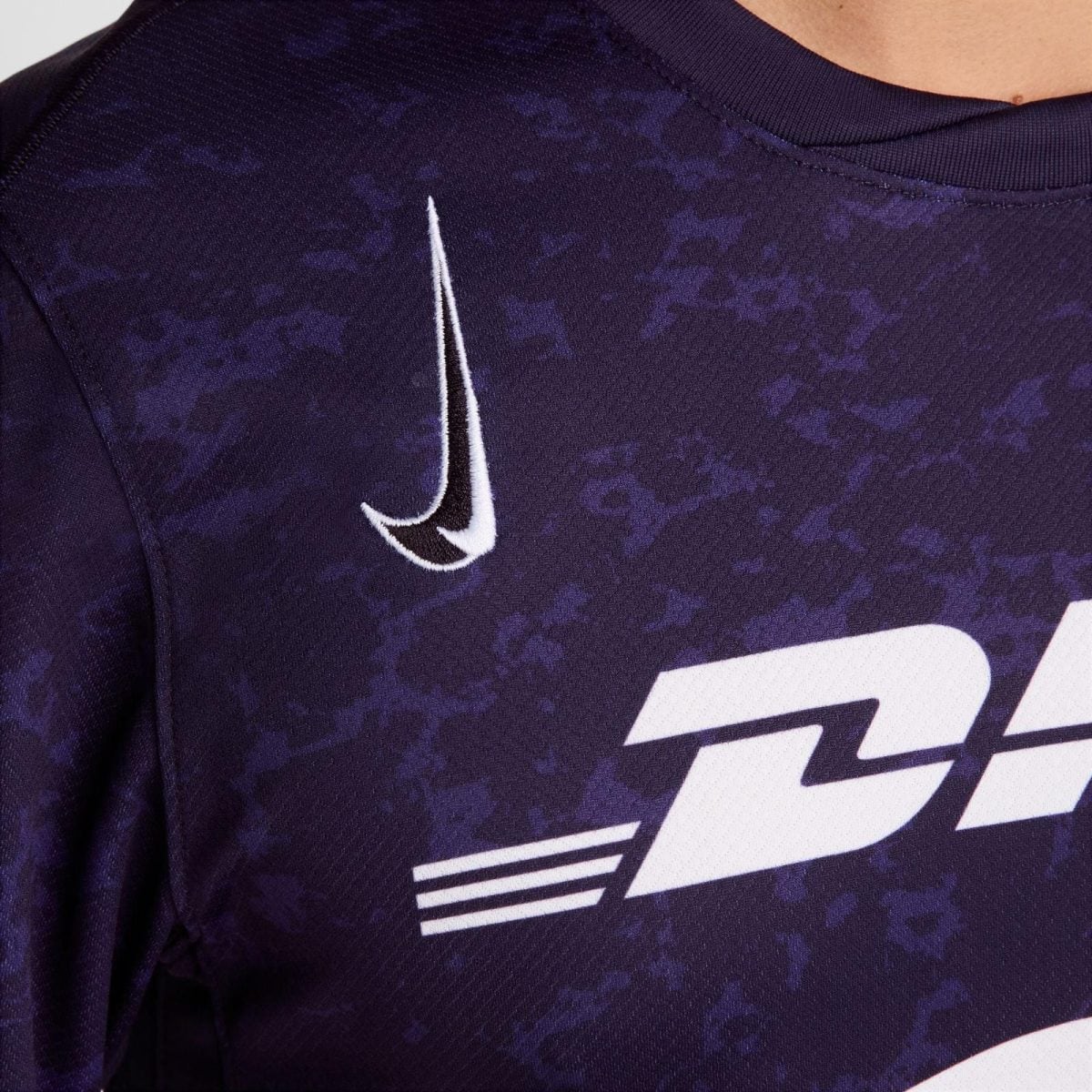 Close-up of a purple patterned sports jersey with a white Nike swoosh logo.