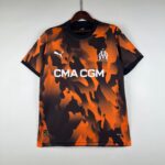 f5406f99_b7ddbc97-ebee-4075-a97e-d3998a70594b | UAE SPORT STORE Orange and black camouflage football jersey on a hanger, displaying the OM crest and CMA CGM text across the front.