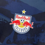 Red Bull Salzburg crest on a dark blue camouflage background.