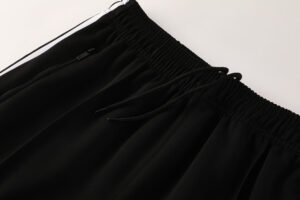 Black athletic pants with an elastic waistband and drawstrings, showing a small zip pocket on the front.