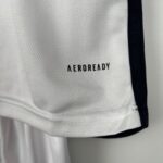 Close-up of white textured fabric with a dark vertical stripe and the word 'AEROREADY' partially visible.