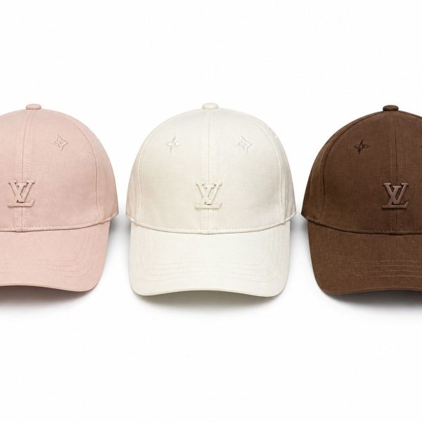 Three Louis Vuitton baseball caps in pink, white, and brown with the LV logo on the front panels.