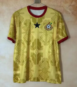 f7a0dea9-b49f-4c3b-98c7-38af384b76fd | UAE SPORT STORE Yellow soccer jersey with red collar and sleeve cuffs, a black star centered on the chest, and a crest with a football on the left. Patterned geometric design all over.