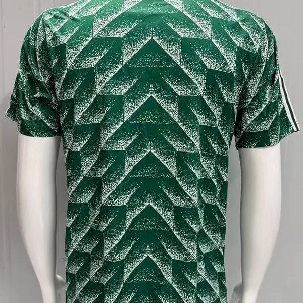 Back view of a green short-sleeve athletic jersey with a white speckled chevron/zigzag pattern across the entire back.