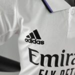 Close-up of white fabric with the black Adidas logo and wordmark printed on it.