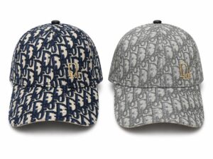 Two Dior monogram baseball caps in navy and gray, each with a gold Dior logo on the front.