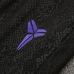 Purple three-blade logo on black textured fabric.