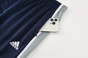 f93a7efc | UAE SPORT STORE Navy Adidas athletic pants with white logo and a smartphone tucked into a side pocket near the waistband.