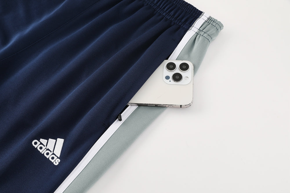 f93a7efc | UAE SPORT STORE Navy Adidas athletic pants with white logo and a smartphone tucked into a side pocket near the waistband.