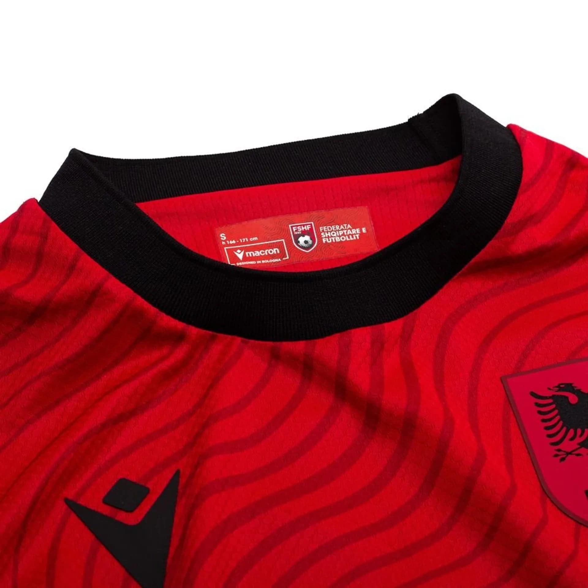 f98160194667 | UAE SPORT STORE Close-up of a red striped shirt neckline with a black ribbed collar and a red care label visible inside the neck area.