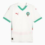 White Morocco national team jersey with green V-neck and zigzag trim, and crest on the chest; red Puma logos on sleeves and chest area