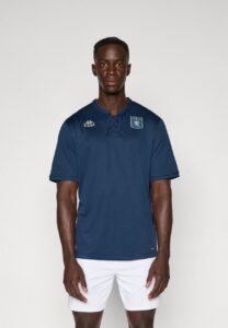 Male model in a navy blue short-sleeve sports shirt with a chest crest and Kappa logo, paired with white shorts.