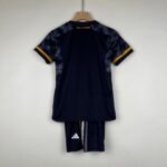 Rear view of a navy Real Madrid football jersey on a wooden hanger; camo-pattern sleeves with yellow cuffs visible at the edges.