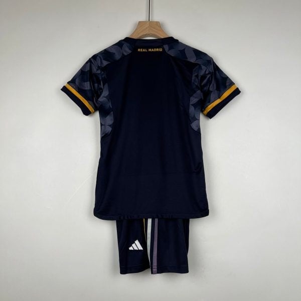 Rear view of a navy Real Madrid football jersey on a wooden hanger; camo-pattern sleeves with yellow cuffs visible at the edges.