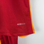 Close-up of a red fabric with orange trim along the edge, possibly part of a bag or athletic gear.
