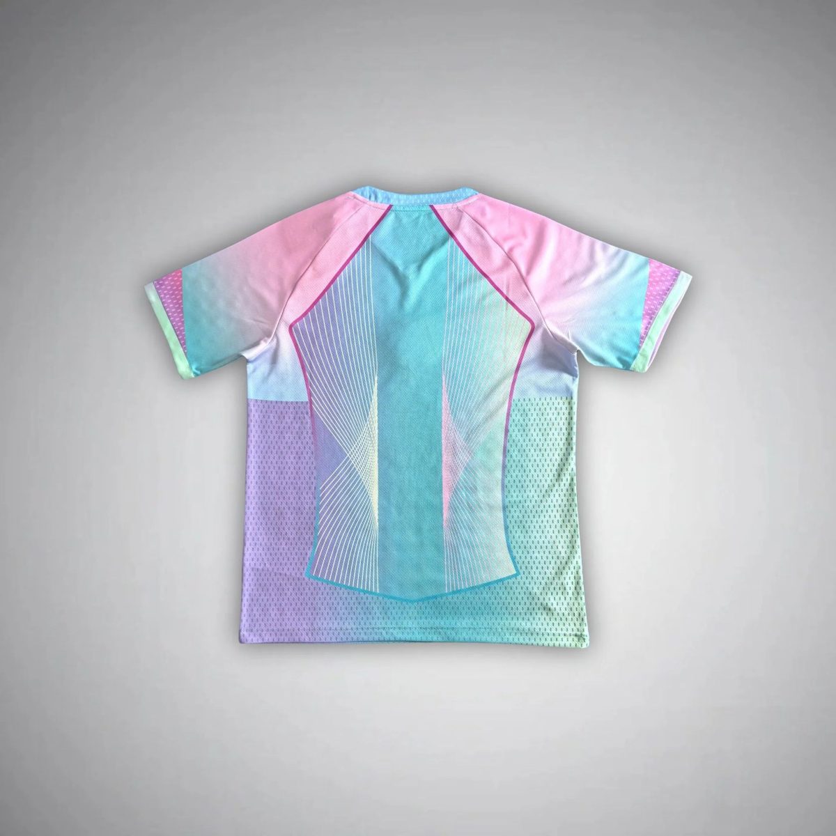 Folded pastel-colored geometric shirt with pink, blue, and teal panels laid flat